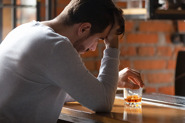 Sad man at the bar with alcohol