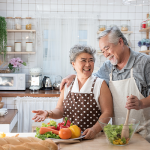 Older Asian couple cooking at home