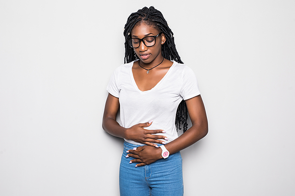 Black woman holding stomach in pain