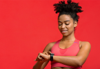 Black woman looking at wearable tracker after exercising