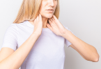 Woman holding thyroid glands on her neck